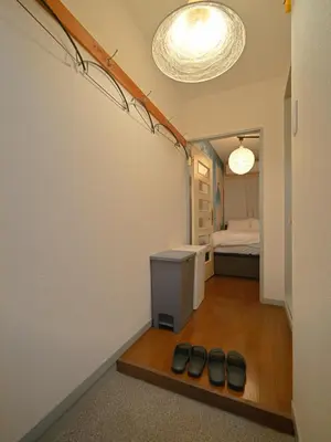 a hallway with a room with a bed and some shoes at The Nest Koenji Cozy Stay near Station Easy Access to Shinjuku in Tokyo