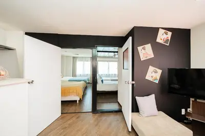a room with a bedroom with a bed and a television at New Large Space 8ppl Flat Apt 2brs&tub in Tokyo
