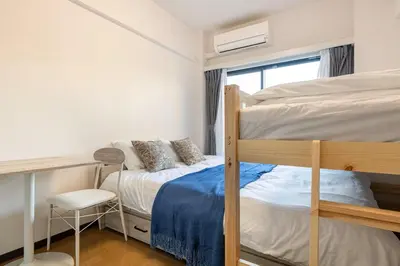 a bedroom with two bunk beds and a desk at \u30a8\u30de\u30fc\u30ec\u65b0\u5bbf401\u53f7\u5ba4 in Tokyo