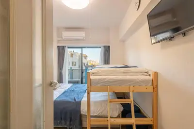 a small room with a bunk bed and a window at \u30a8\u30de\u30fc\u30ec\u65b0\u5bbf401\u53f7\u5ba4 in Tokyo