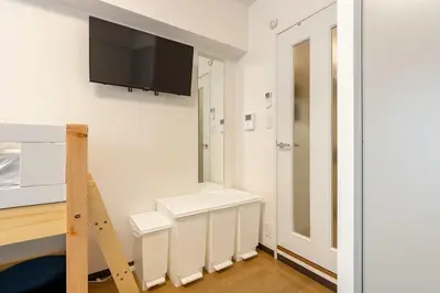 a room with a flat screen tv on a wall at \u30a8\u30de\u30fc\u30ec\u65b0\u5bbf401\u53f7\u5ba4 in Tokyo