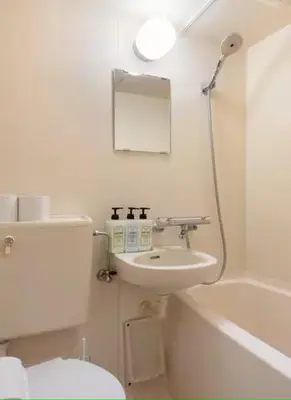 a white bathroom with a sink and a toilet at \u30a8\u30de\u30fc\u30ec\u65b0\u5bbf401\u53f7\u5ba4 in Tokyo
