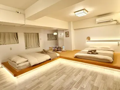 two beds in a large room with wooden floors at \u685c\u5357\u5927\u585a\u30cf\u30a6\u30b9 i in Tokyo