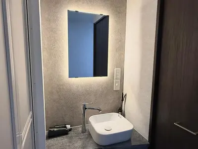 a bathroom with a white toilet and a mirror at \u685c\u5357\u5927\u585a\u30cf\u30a6\u30b9ii in Tokyo