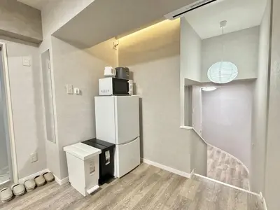 a kitchen with a white refrigerator and a staircase at \u685c\u5357\u5927\u585a\u30cf\u30a6\u30b9ii in Tokyo