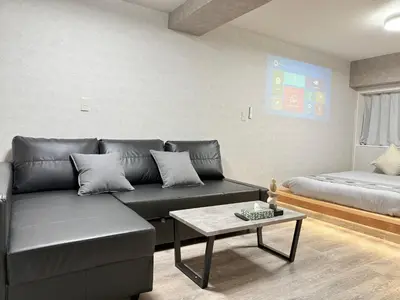 a living room with a couch and a bed at \u685c\u5357\u5927\u585a\u30cf\u30a6\u30b9ii in Tokyo
