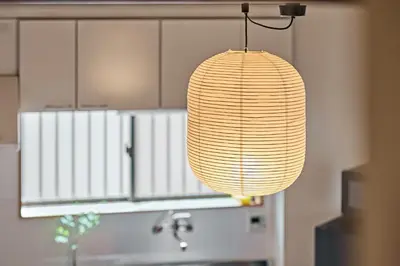 a light fixture hanging from a wall in a kitchen at Pufuka\u6771\u5411\u5cf6\u5317\u516c\u5712 in Tokyo