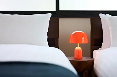 a red lamp sitting on a table between two beds at Pufuka\u6771\u5411\u5cf6\u5317\u516c\u5712 in Tokyo