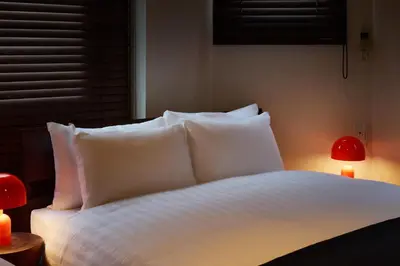 a bed with white pillows and a red lamp at Pufuka\u6771\u5411\u5cf6\u5317\u516c\u5712 in Tokyo