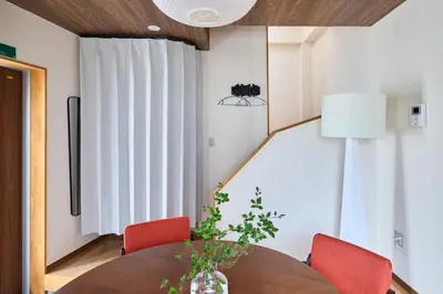 a dining room with a table and red chairs at Pufuka\u6771\u5411\u5cf6\u5317\u516c\u5712 in Tokyo