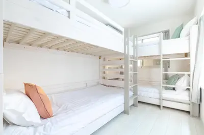 a bedroom with two bunk beds with white walls at Downtown Mix in Tokyo