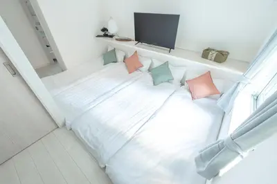 a white bed with pillows on it in a room at Downtown Mix in Tokyo