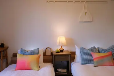 a bedroom with two beds and a table with a lamp at Mi-HOTEL ATELIER SHINJUKU in Tokyo