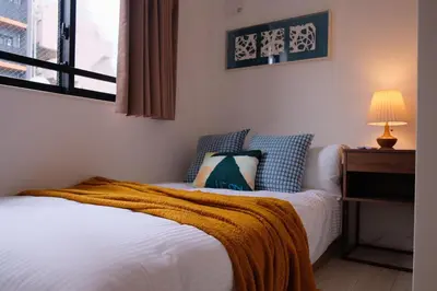 a bedroom with a bed and a lamp and a window at Mi-HOTEL ATELIER SHINJUKU in Tokyo