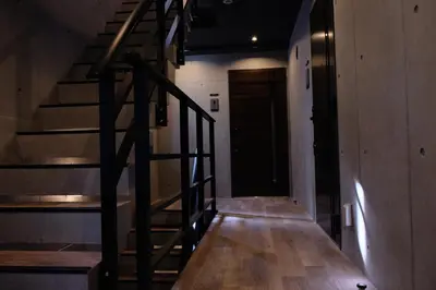 a hallway with a wooden staircase and a door at Mi-HOTEL ATELIER SHINJUKU in Tokyo