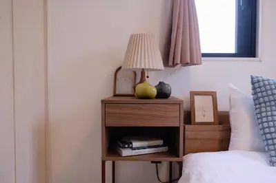 a lamp on a night stand next to a bed at Mi-HOTEL ATELIER SHINJUKU in Tokyo
