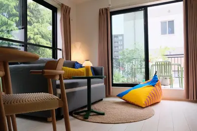 a living room with a couch and large windows at Mi-HOTEL ATELIER SHINJUKU in Tokyo