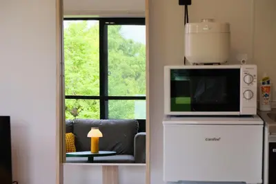 a living room with a microwave and a couch at Mi-HOTEL ATELIER SHINJUKU in Tokyo