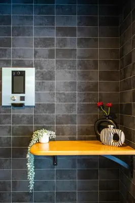 a bathroom with a shelf with flowers and a microwave at Mi-HOTEL ATELIER SHINJUKU in Tokyo