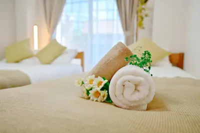 a towel on a bed with flowers on it at Subway 2min Skytree#6min Asakusa in Tokyo
