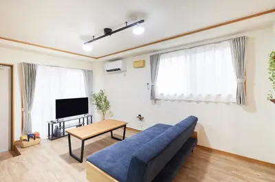 a living room with a blue couch and a tv at Est Stay KOIWA - Private Tokyo Apartment with Easy Access to Airport and Popular Attractions in a Calm and Friendly Neighborhood in Tokyo