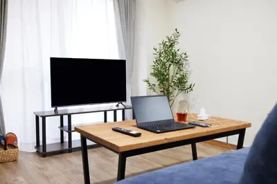 a living room with a table with a laptop and a tv at Est Stay KOIWA - Private Tokyo Apartment with Easy Access to Airport and Popular Attractions in a Calm and Friendly Neighborhood in Tokyo