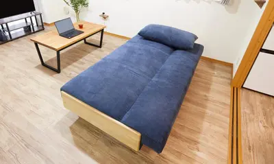 a blue couch in a living room with a laptop on a table at Est Stay KOIWA - Private Tokyo Apartment with Easy Access to Airport and Popular Attractions in a Calm and Friendly Neighborhood in Tokyo