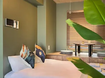 a bedroom with a bed with pillows and a table at nestay apartment tokyo komagome in Tokyo