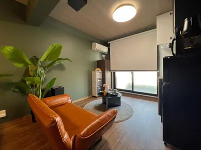 a living room with a leather couch and a window at nestay apartment tokyo komagome in Tokyo