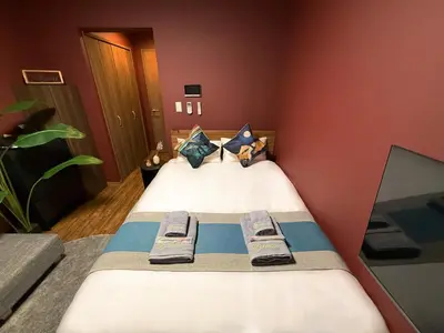 a bedroom with a bed with two slippers on it at nestay apartment tokyo komagome in Tokyo