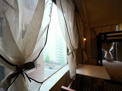 a window with a curtain with a view of a building at UENO 704 jellynehouse in Tokyo