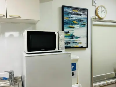 a tv sitting on top of a refrigerator with a painting at \u6c60\u888bHouse1F 2bedrooms suite Cozy for 1-4 guests in Tokyo