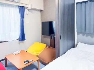 a room with a bed and a table and a tv at Triphome Shinjuku East 4F in Tokyo