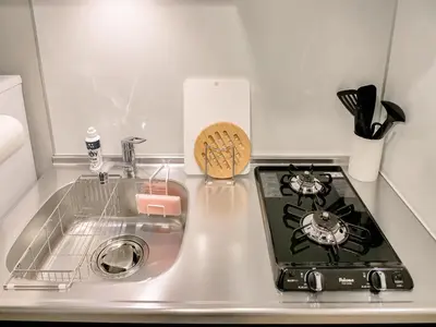 a kitchen counter with a stove and a sink at Triphome Nakano 2025 Green in Tokyo
