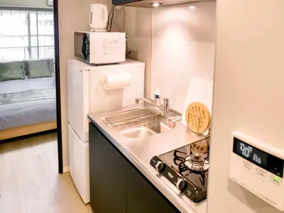 a small kitchen with a sink and a refrigerator at Triphome Nakano 2025 Green in Tokyo