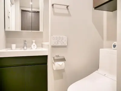 a bathroom with a toilet and a sink at Triphome Nakano 2025 Green in Tokyo