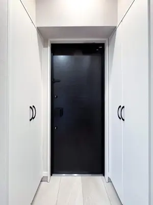 a black door in a hallway with white walls at Triphome Nakano 2025 Penthouse in Tokyo