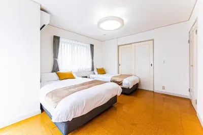 a bedroom with two beds and a window at Poka villa aoyama - Vacation STAY 19050 in Tokyo