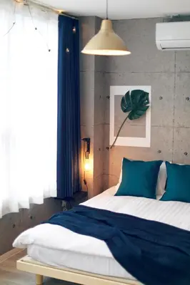 a bedroom with a large bed with blue pillows at Miraisya Hikifune in Tokyo