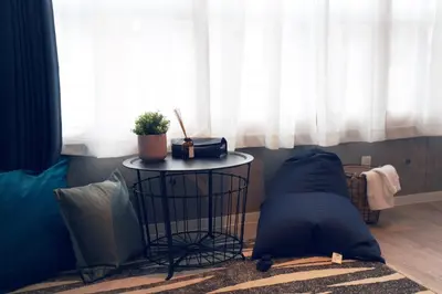 a room with a table with a pillow and a window at Miraisya Hikifune in Tokyo