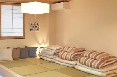 a room with a pile of pillows on the floor at Miraisya Hikifune in Tokyo