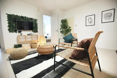 a living room with wicker chairs and a flat screen tv at Miraisya Hikifune in Tokyo