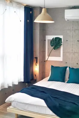 a bedroom with a large bed with a blue blanket at Miraisya Hikifune in Tokyo