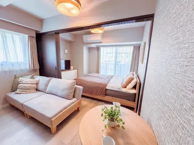 a bedroom with a bed and a couch and a table at Triphome Nakano 2025 Cozy in Tokyo
