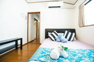 a bedroom with a bed with blue and white pillows at \u65b0\u5bbf\u4e45\u4e45\u5c0f\u6728\u5c4b \u6574\u680b\u51fa\u79df in Tokyo