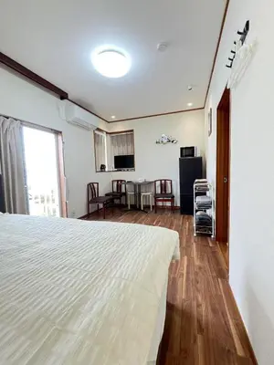 a bedroom with a white bed and a kitchen at Takara\u8c4a\u5cf6\u5712201 NR0435 in Tokyo
