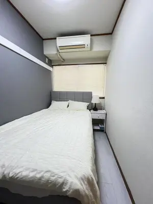a small bedroom with a white bed and a window at Takara\u8c4a\u5cf6\u5712201 NR0435 in Tokyo