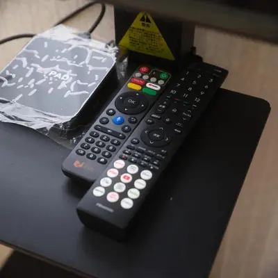 two remote controls sitting on top of a table at \u685c\u306e\u5bbf in Tokyo