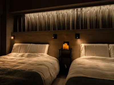 a bedroom with two beds and a window with curtains at Akihabara Sta 13min, Kanda Sta 10min,Ogawamachi 2min,Hotel Prime Inn Kanda, in Tokyo