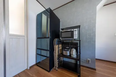 a room with a black book shelf and a microwave at Sakura in Tokyo